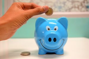 blue piggy bank with smiley face and gold coins