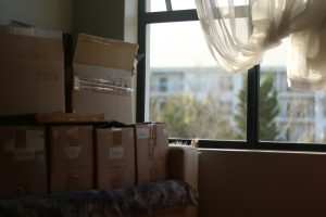 a room with boxes stacked by a window