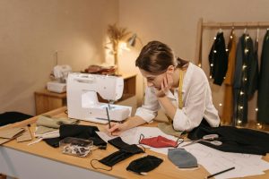 woman with a small business making masks writing on paper