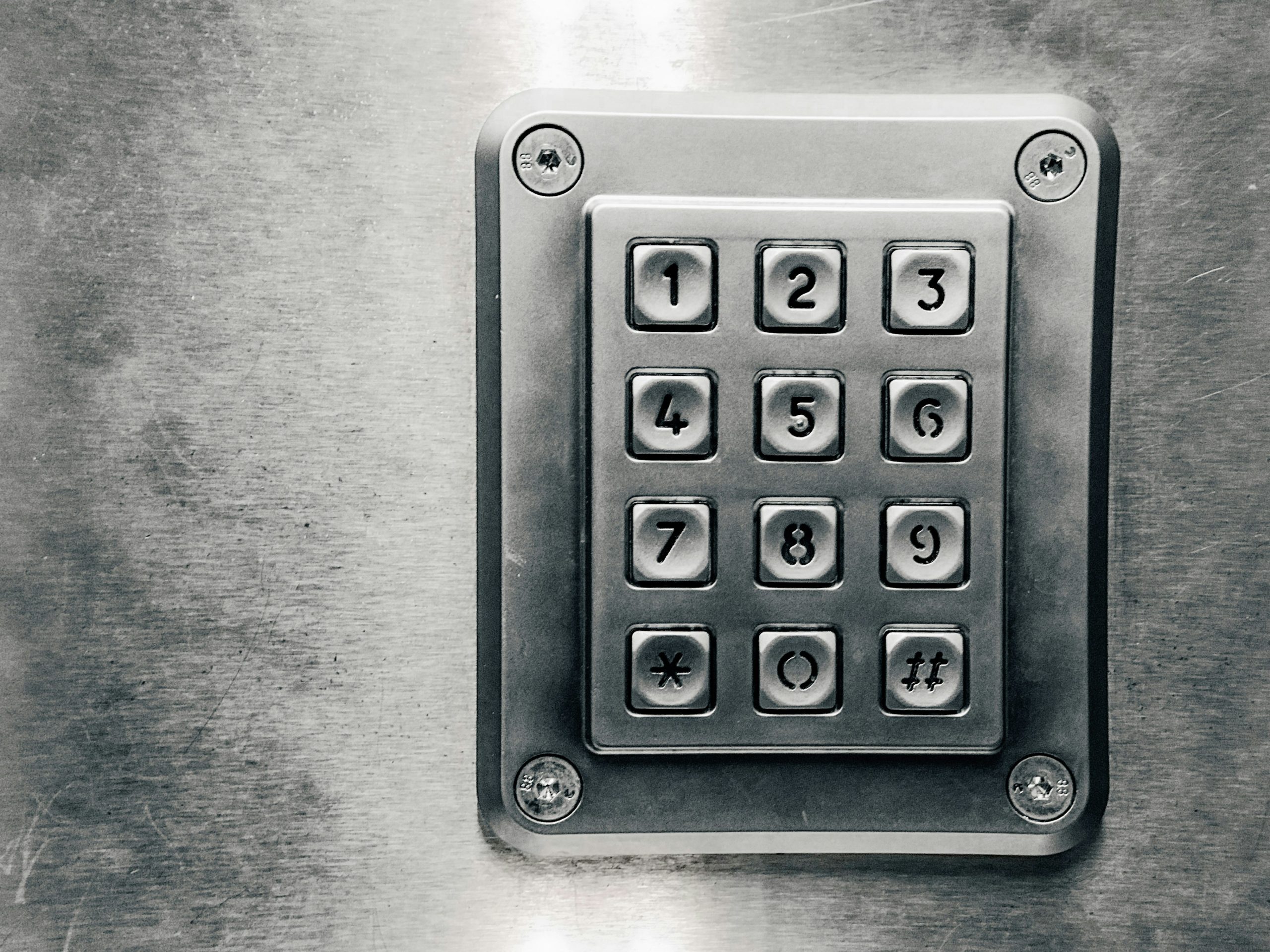 a-close-up-of-a-metal-key-pad-with-numbers-on-it